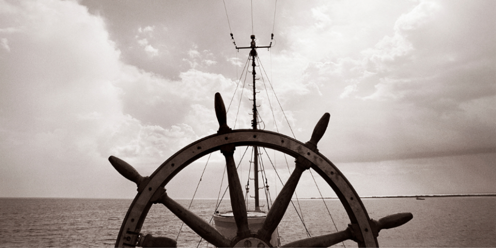 Black and white ship's wheel and mast